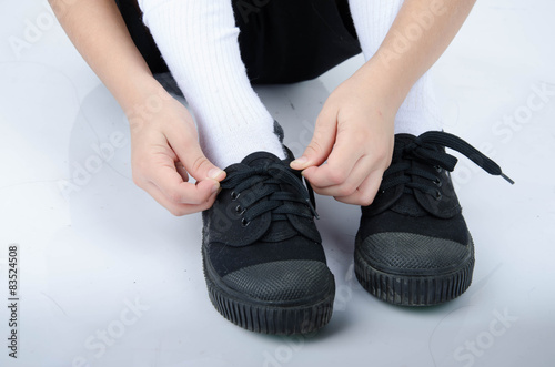 Little boy tie shoes ready for school on white background © wckiw
