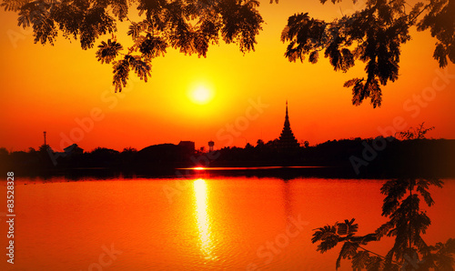 Thailand, Khon Kaen Province, Khon Kaen, Ban Ganyarat, Rob Bueng Road, Bueng Kaen Nakhon, Sunset and temples over Bueng Kaen Nakhon Lake photo