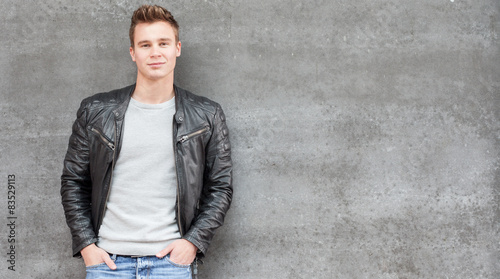 Casual young guy in front of concrete wall