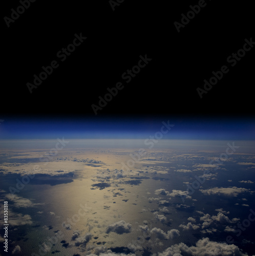 The Earth in space with clouds over the open sea.
