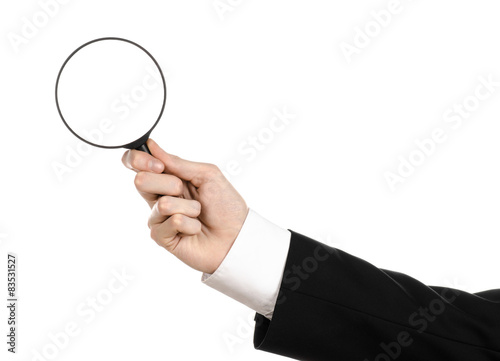 businessman in a black suit holding a magnifying glass