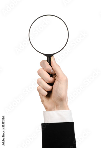 businessman in a black suit holding a magnifying glass