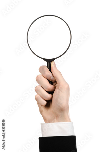 businessman in a black suit holding a magnifying glass