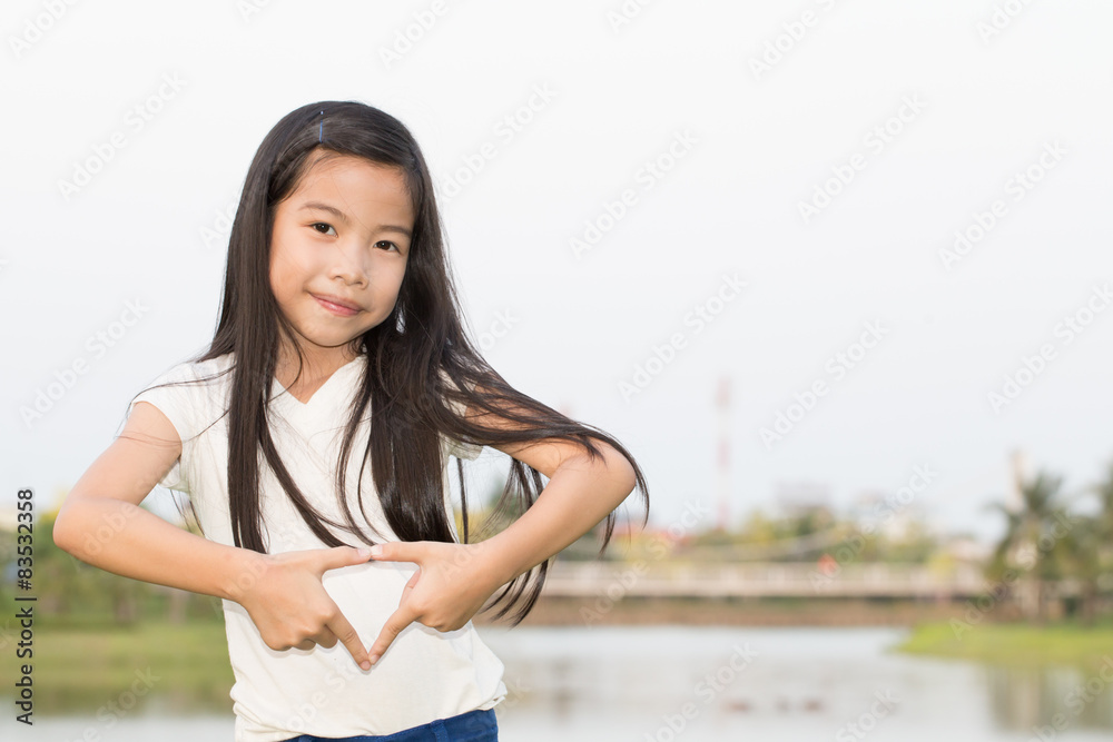 Young Asian girl making heart with hands
