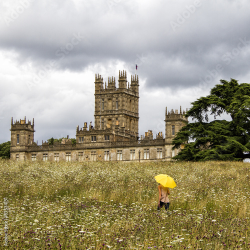 UK, Hampshire, Highclere Castle, Woman with yellow umbrella on meadow photo