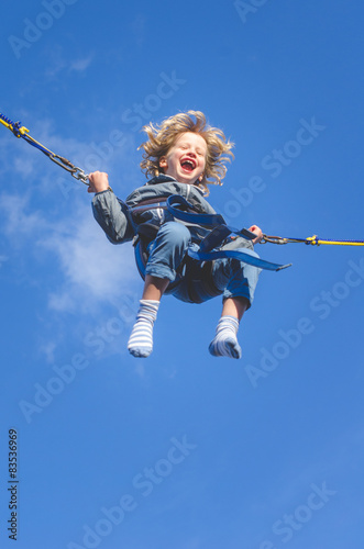 Smiling boy (6-7) on bungee swing photo
