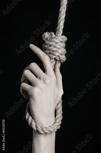 human hand hanging on rope loop on a black background
