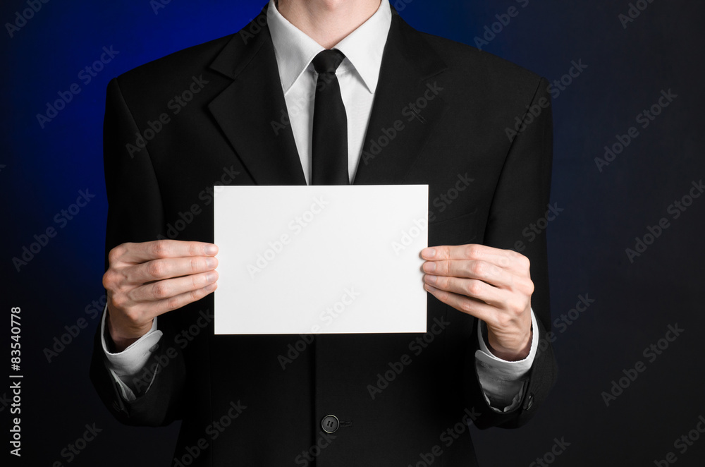 Man in black suit holding a white blank card in his hand Man in black suit holding a white blank card in his hand