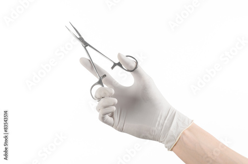 doctor's hand in a white glove holding a surgical clip isolated