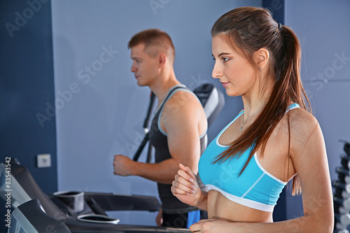 Man and woman on treadmill in gym