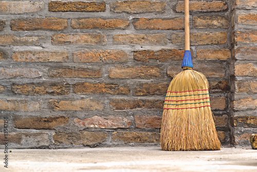 Household Broom For Floor Cleaning Leaning on Brick Wall photo