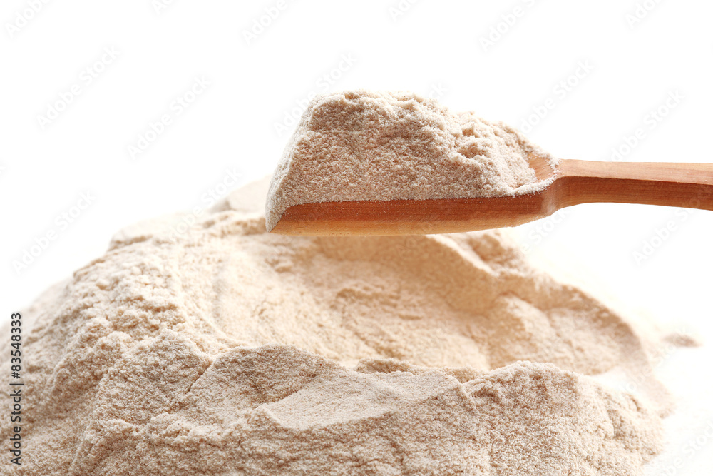 Heap of flour with wooden spoon close up Heap of flour with wooden spoon close up