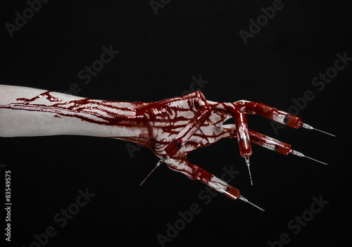 Bloody hand with syringe on the fingers, toes syringes in studio