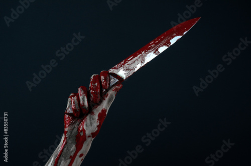 zombie killer holding a large bloody knife isolated in studio