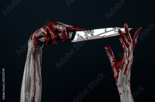 zombie killer holding a large bloody knife isolated in studio