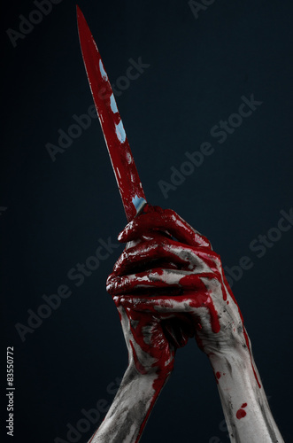 zombie killer holding a large bloody knife isolated in studio