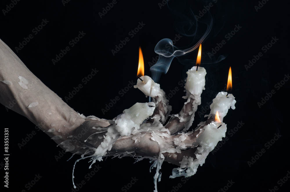 Obraz premium on the hand wearing a candle and dripping melted wax studio