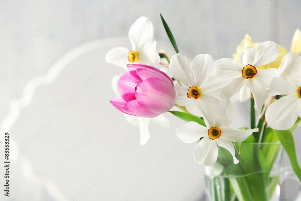 Spring bouquet in glass mug on color wooden background Spring bouquet in glass mug on color wooden background