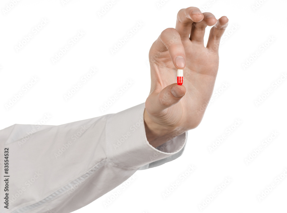 doctor's hand holding a red capsule for health isolated doctor's hand holding a red capsule for health isolated