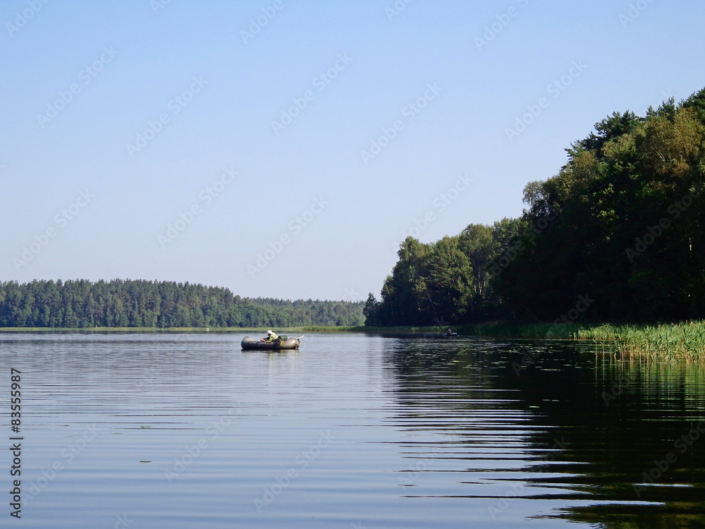 Fisherman in the inflatable rubber dinghy on the lake