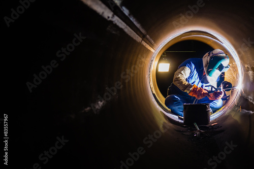 Workers welding work at night in the pipeline.