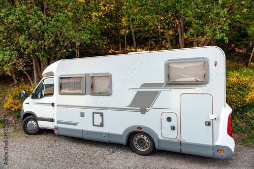 Camping van microbus parked in summer forest