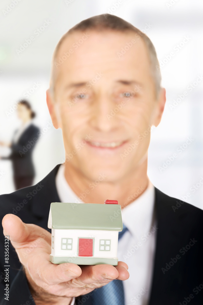 Businessman with small house.