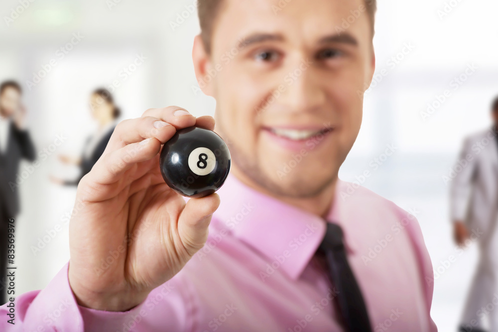 Fototapeta premium Young businessman holding billiard ball.