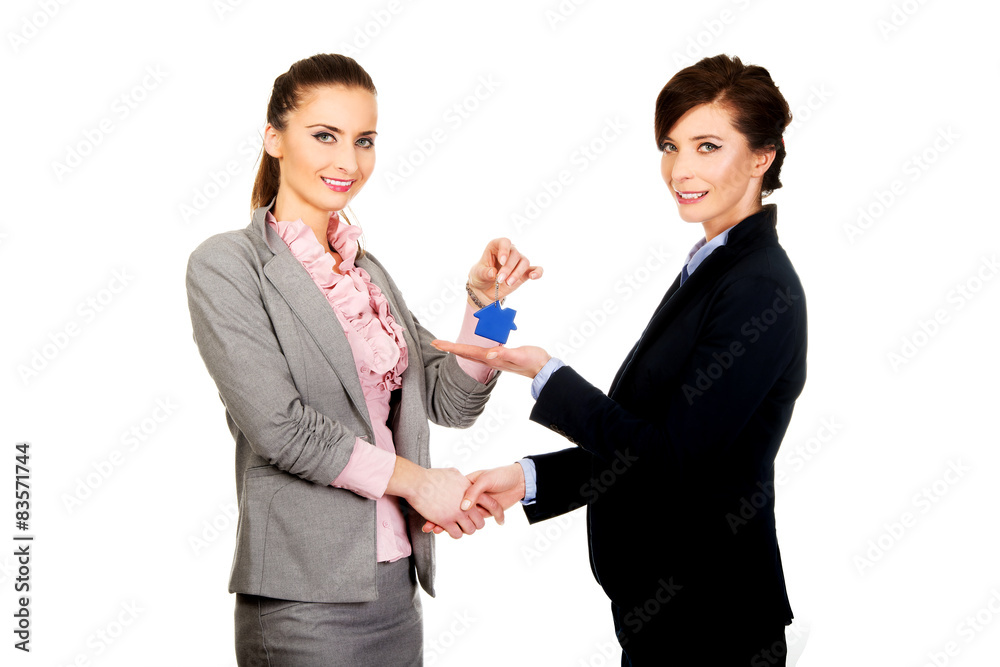 Businesswoman giving a key to her partner. Businesswoman giving a key to her partner.