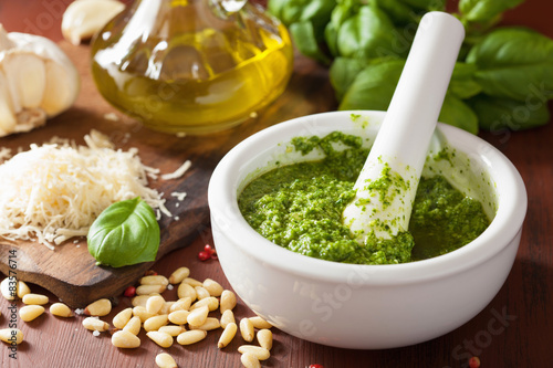 Fotografia pesto sauce and ingredients over wooden rustic background