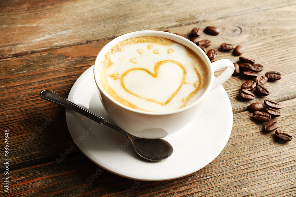 Cup of coffee latte art with grains on wooden background Cup of coffee latte art with grains on wooden background