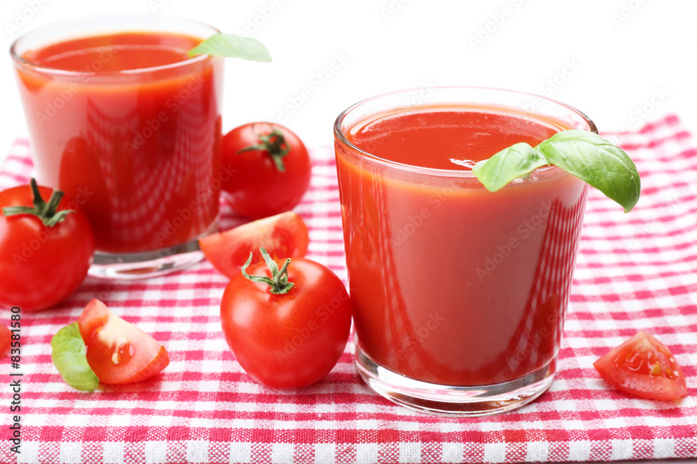 Glasses of fresh tomato juice on checkered napkin, isolated on white Glasses of fresh tomato juice on checkered napkin, isolated on white