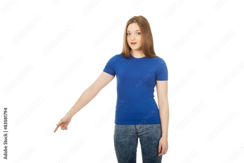 Shocked young woman pointing down. Shocked young woman pointing down.
