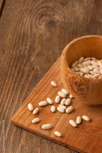 Beans in a wood pot on natural textured wood background