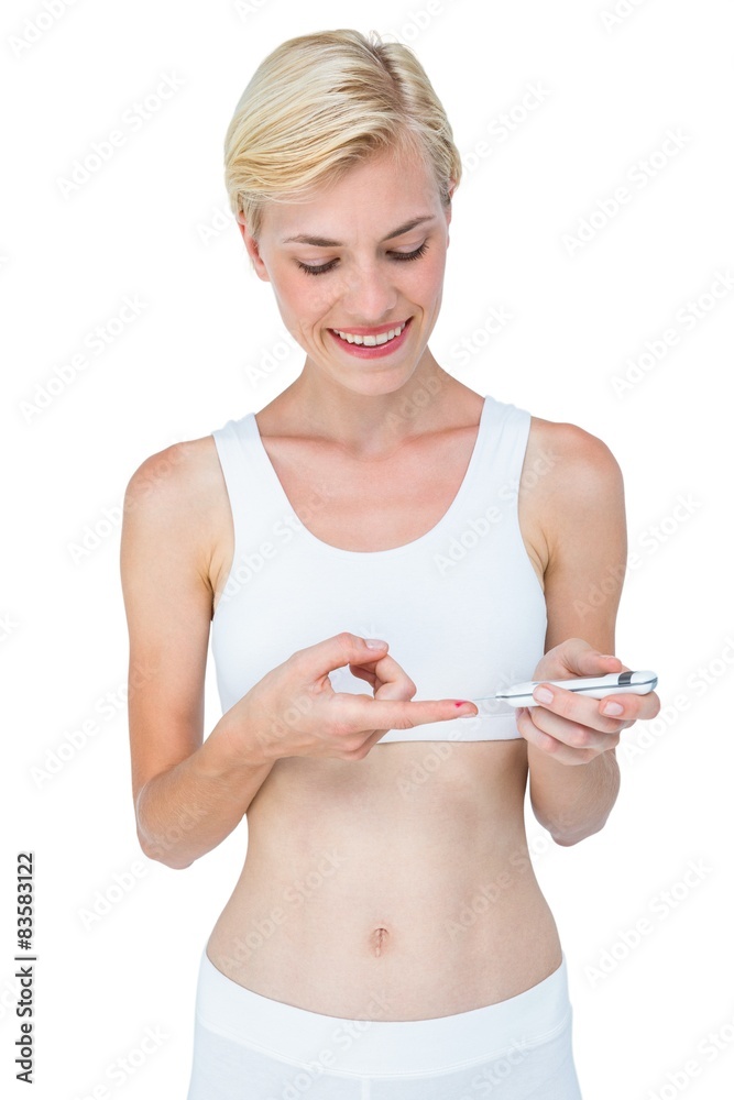 Attractive blonde woman doing test with blood glucose monitor Attractive blonde woman doing test with blood glucose monitor