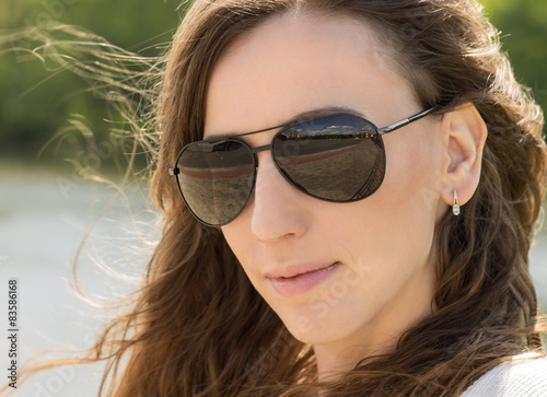 Close up portrait of young woman in black glasses.