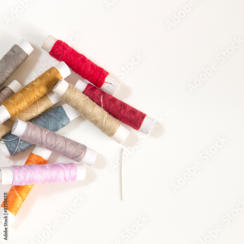 Colored sewing threads on a white table