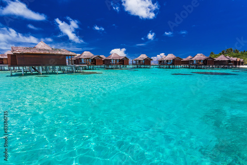 Luxurious overwater bungallows in the lagoon on a tropical islan © Martin Valigursky