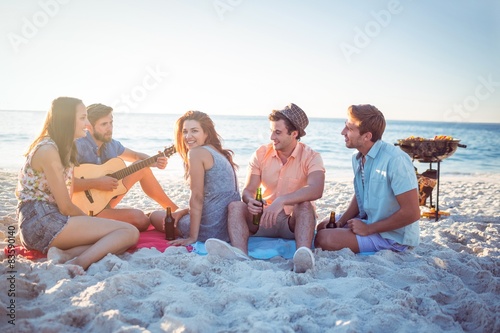 Happy hipsters relaxing and playing guitar