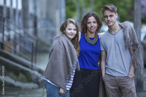 Woman with her older children outdoors.