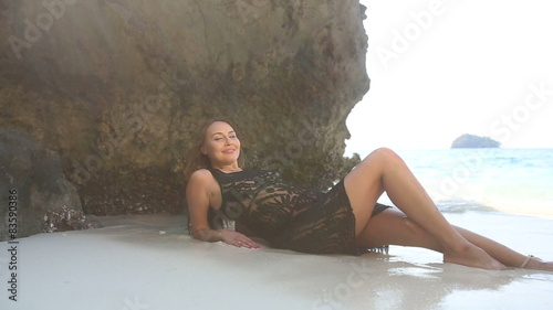 brunette girl half dressed in lace frock lies  on sand