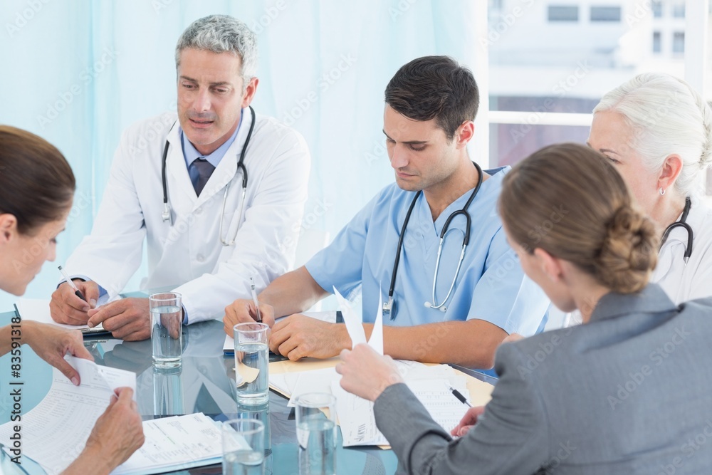 Male and female doctors working on reports