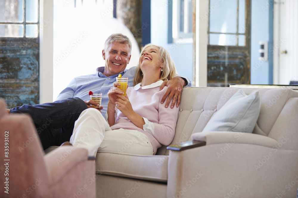 Mature Couple At Home Relaxing In Lounge With Cold Drinks Mature Couple At Home Relaxing In Lounge With Cold Drinks