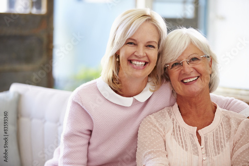 Senior Mother With Adult Daughter Relaxing On Sofa