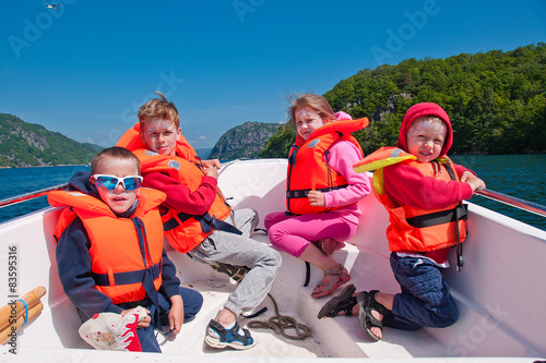 Kids in lifejackets in a boat