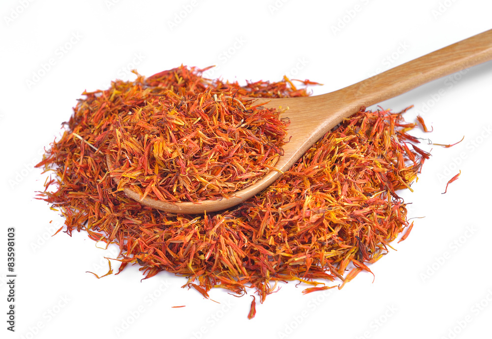 Fototapeta premium Safflower petals in a spoon on white background
