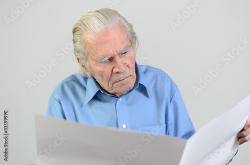 Älterer Mann hält ein großes leeres Blatt wie eine Zeitung
