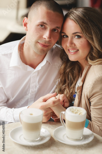 Happy couple drinking coffee in a local cafe.