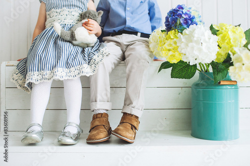 Baby boy and girl sitting on a wooden floor