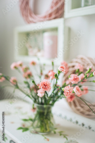 Beautiful pink flowers in a vase on white rustic table
